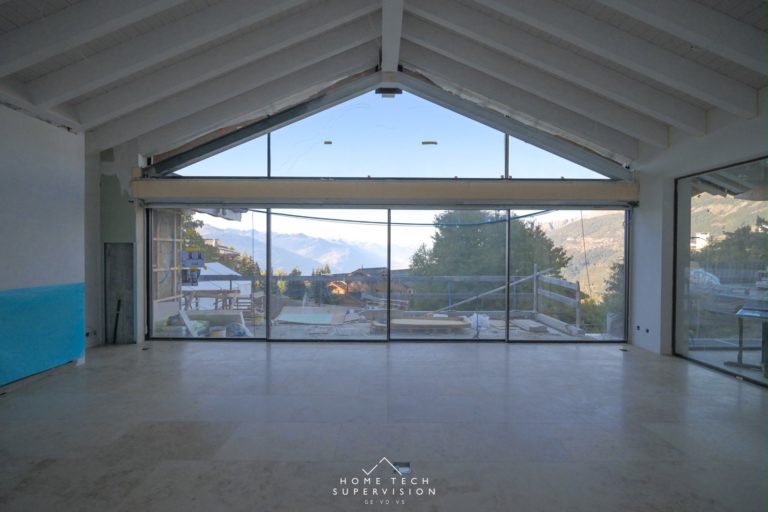 Chalet en cours à Crans-Montana, baie vitrée face aux Alpes – éclairage Lutron