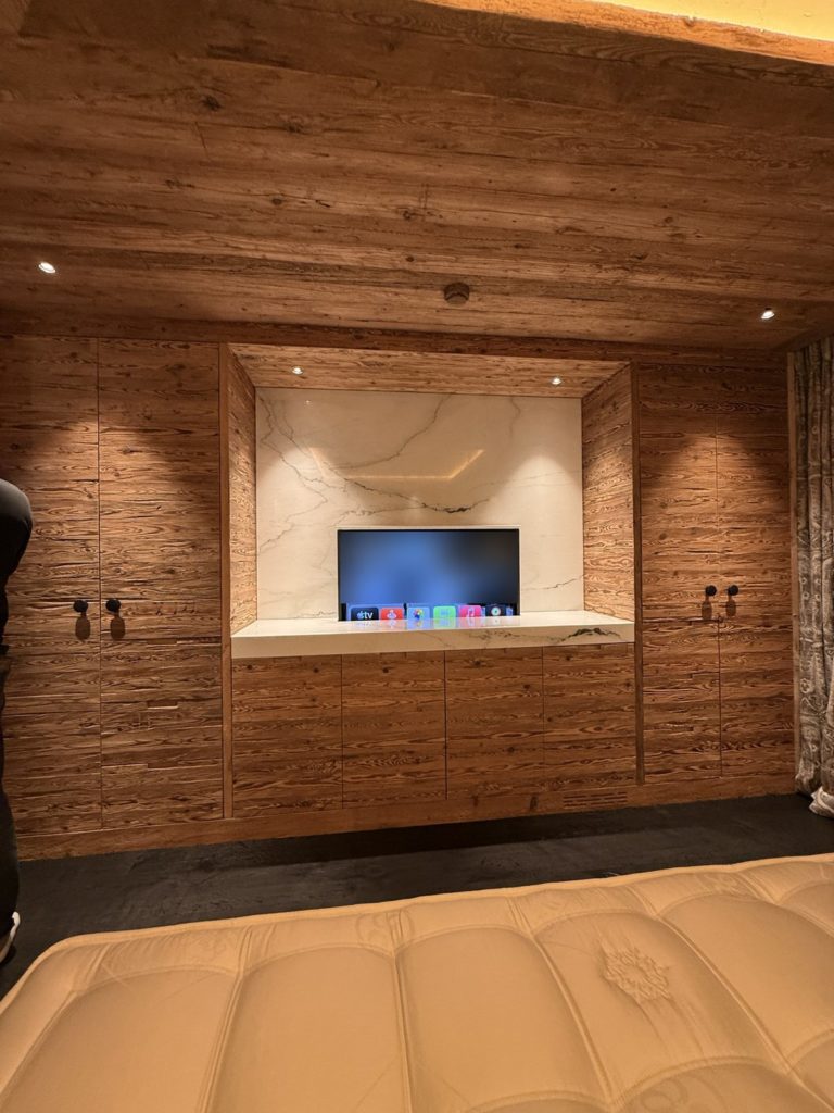 Téléviseur sur lift dans un meuble en marbre