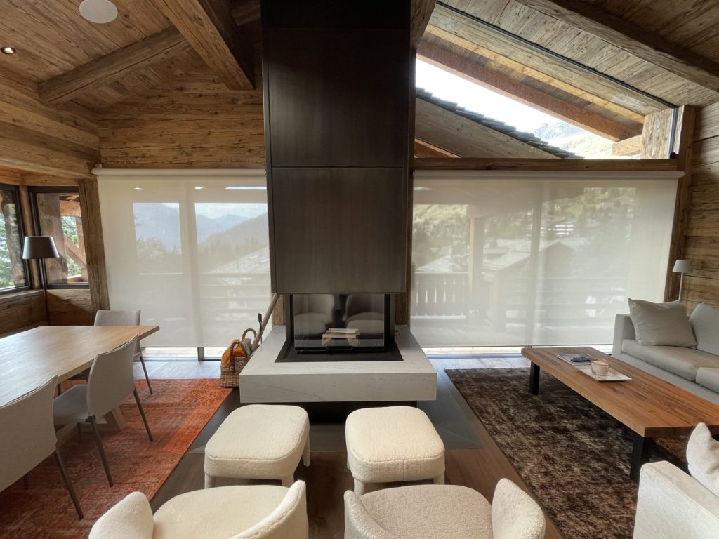 Stores toile Lutron Palladiom baissés dans le salon d'un chalet à Verbier